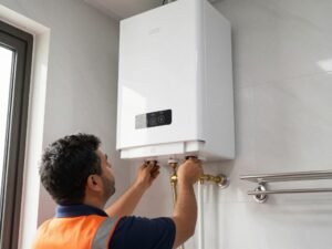 فني صحي يقوم بتركيب سخان مياه حديث في منزل بالكويت