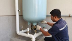 فني يقوم بتصليح سخانات مركزية في الكويت